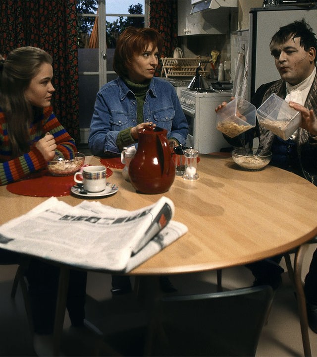 "Sprechstunde bei Dr. Frankenstein": Franzi (Floriane Eichhorn), Charly (Silke Matthias) und Lenni ((Michael Trischan) sitzen beim Frühstück an einem runden Tisch in der Küche.