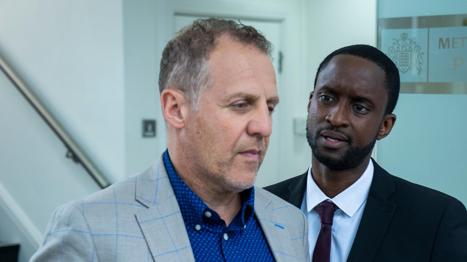 "The Chelsea Detective - Spiel auf Leben und Tod": Connor (Peter Bankolé) steht neben Ricky (Nigel Lindsay) und spricht ihn an. Im Hintergrund ein Treppenhaus.
