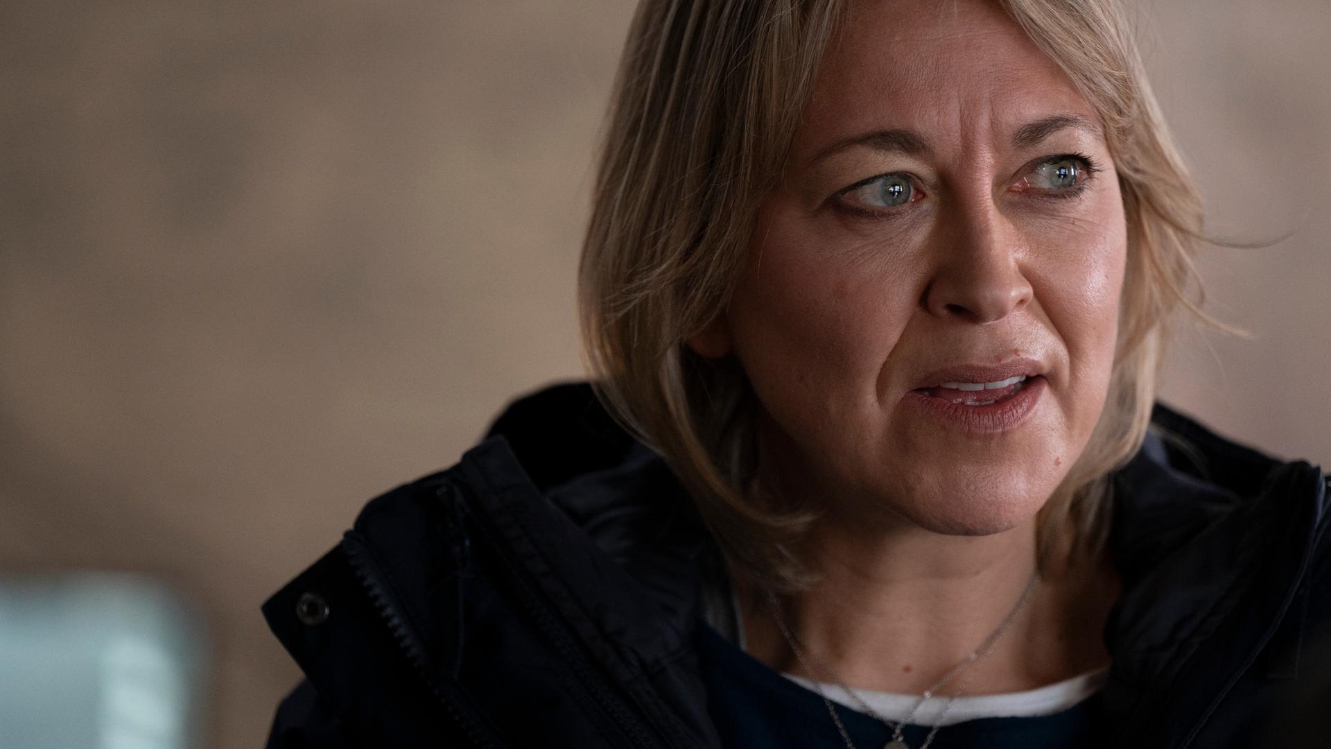 Nahaufnahme von Annika Strandhed (Nicola Walker), einer Frau mittleren Alters mit schulterlangen, dunkelblonden Haaren, die den Eindruck einer erfahrenen Polizistin vermittelt.