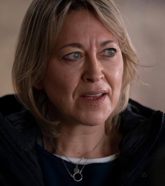 Nahaufnahme von Annika Strandhed (Nicola Walker), einer Frau mittleren Alters mit schulterlangen, dunkelblonden Haaren, die den Eindruck einer erfahrenen Polizistin vermittelt.
