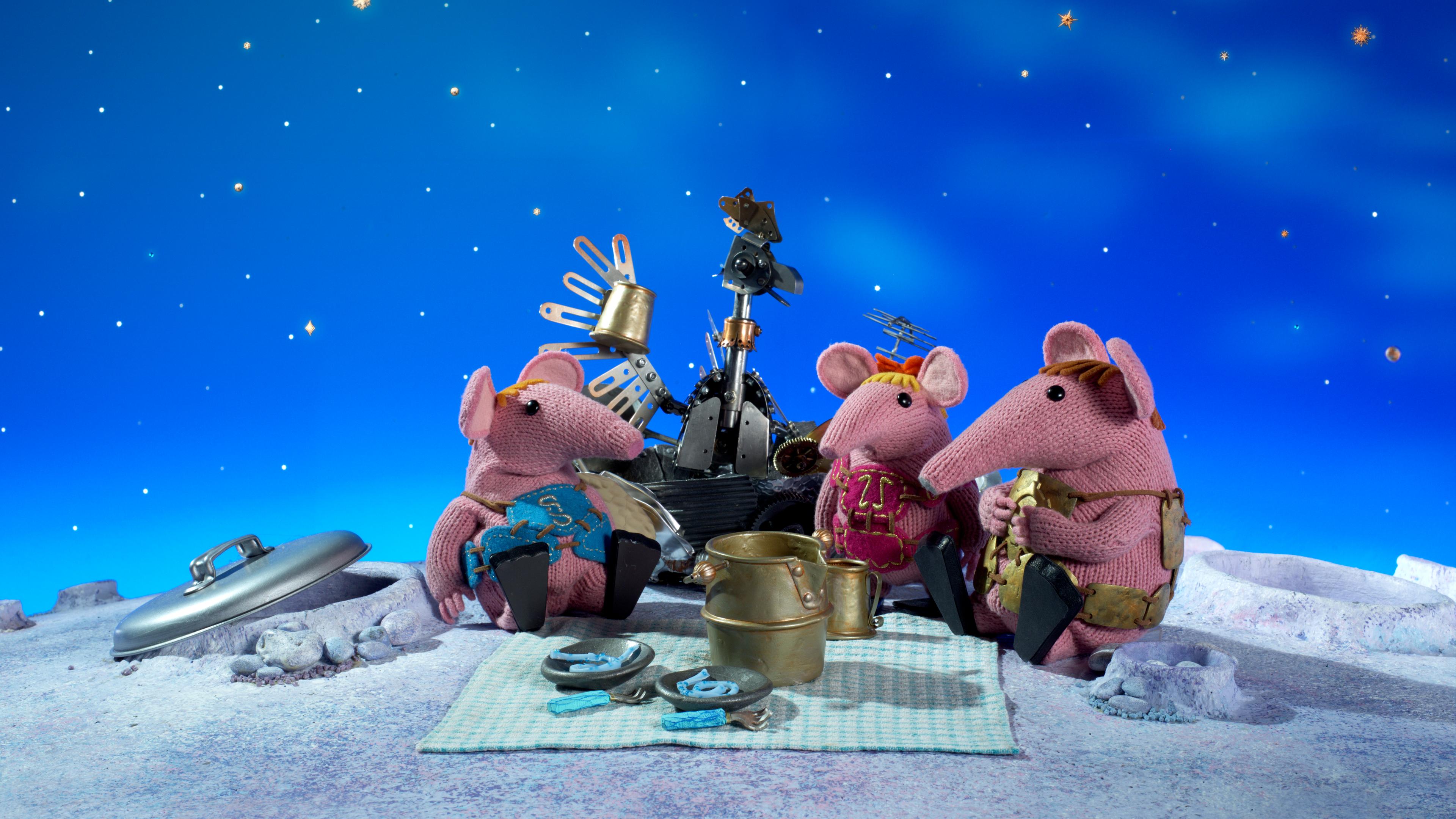 Es ist Abend, die Sterne leuchten: Papa Clanger und seine Kinder Klein und Klitzeklein sitzen mit dem Blechhuhn auf einer Decke, auf der das Picknick ausgebreitet ist.