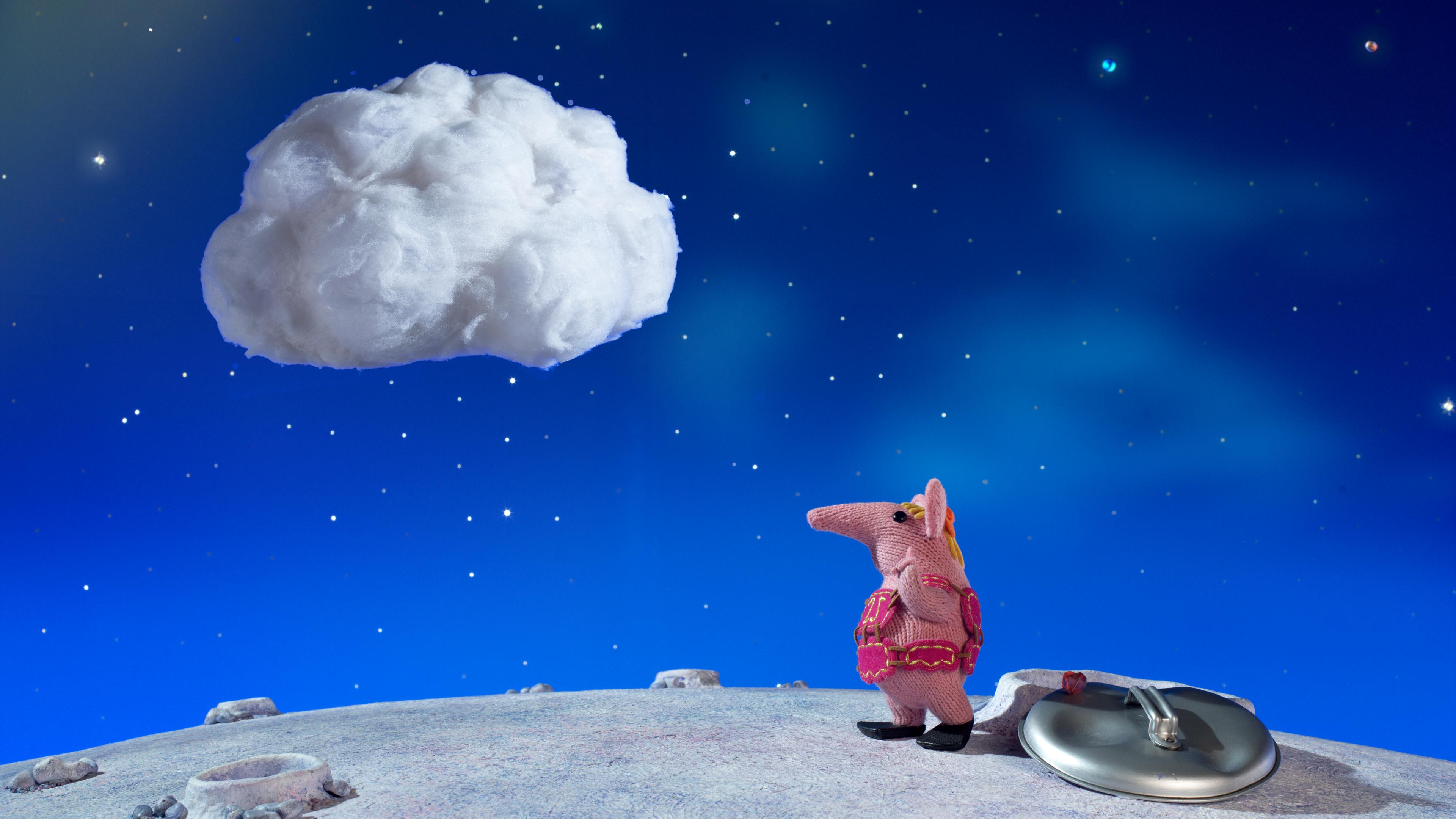 Klitzeklein Clanger steht auf dem Planeten und schaut zu einer  Wolke hoch, die über ihr schwebt.