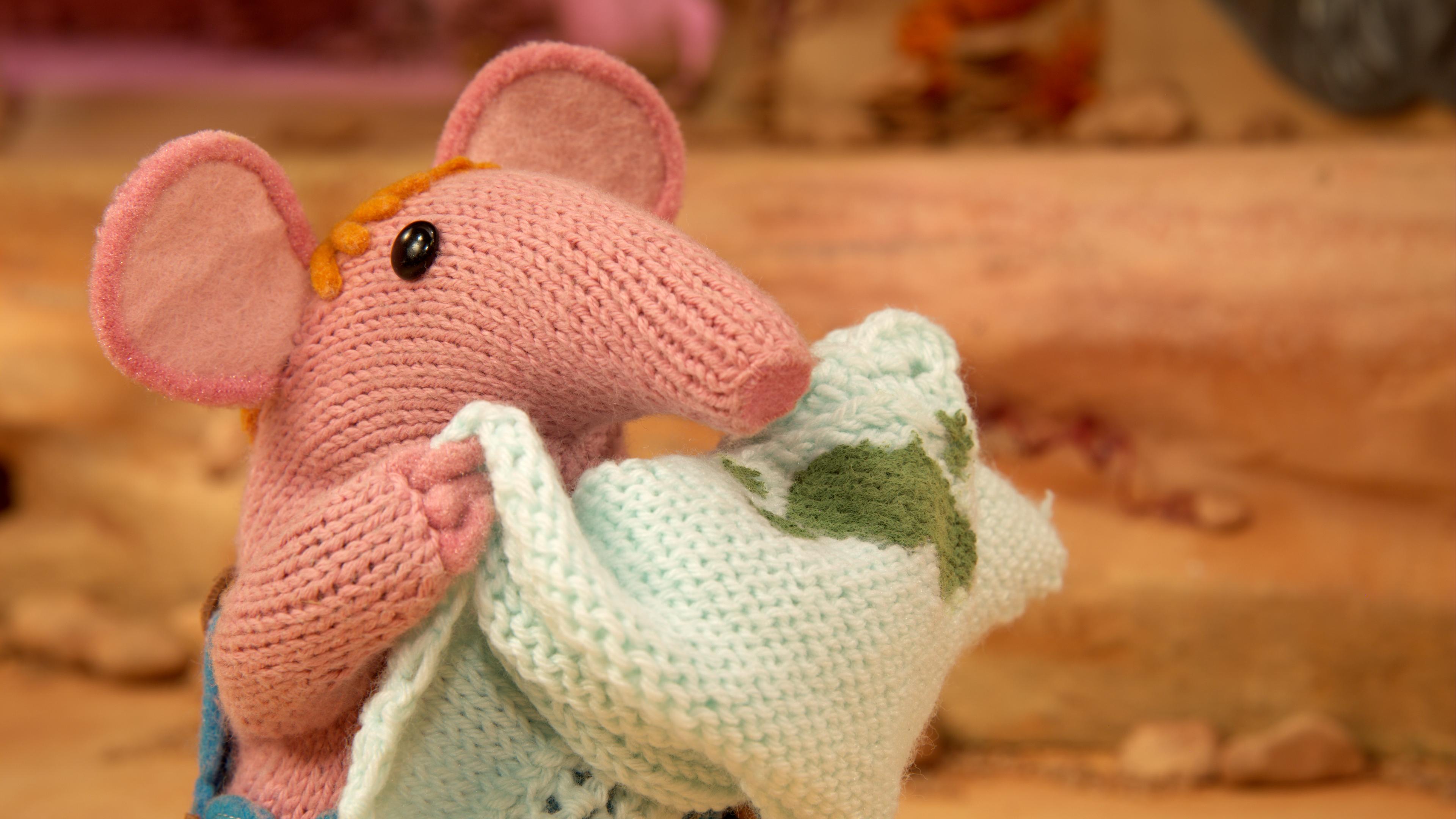 Klein Clanger hält den Schal von Oma Clanger hoch. Dieser hat einen großen grünen Fleck.