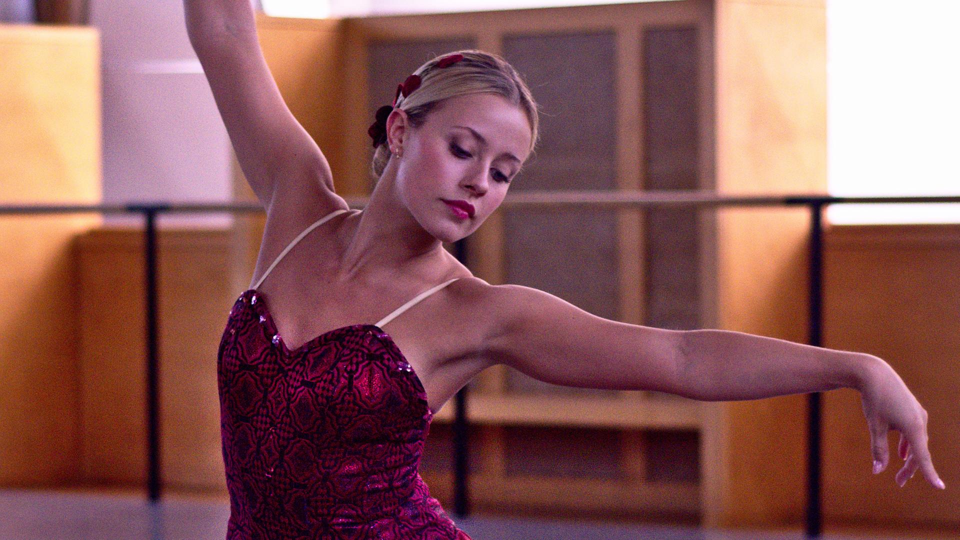 Lena (mittig) tanz in einem roten Kleid.