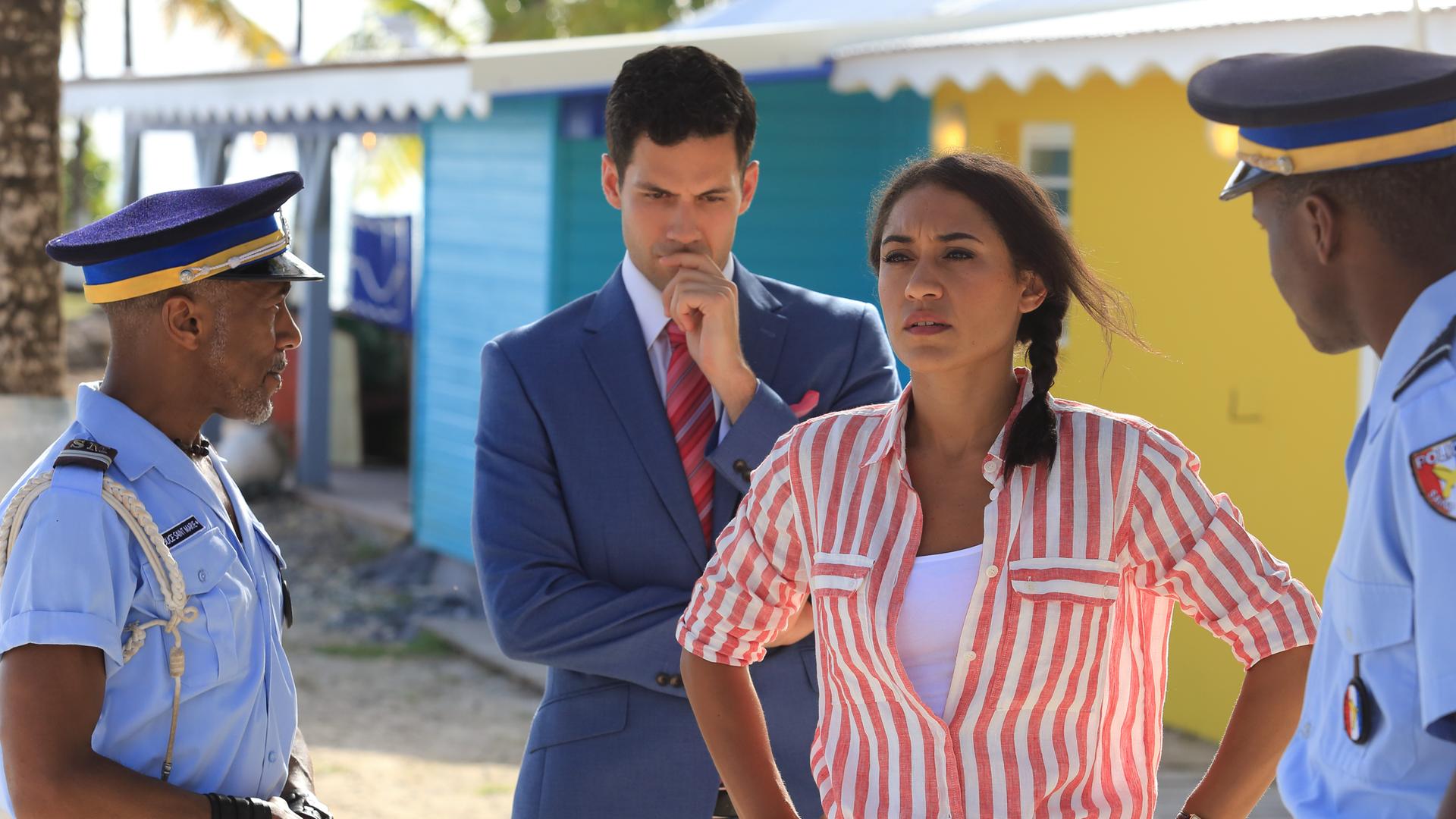 "Death in  Paradise - Die tote Braut": Florence Cassell (Josephine Jobert) steht zwischen Dwayne (Danny John-Jules), Oliver (Stefano Braschi) und J.P. (Tobi Bakare) und schaut in die Ferne.