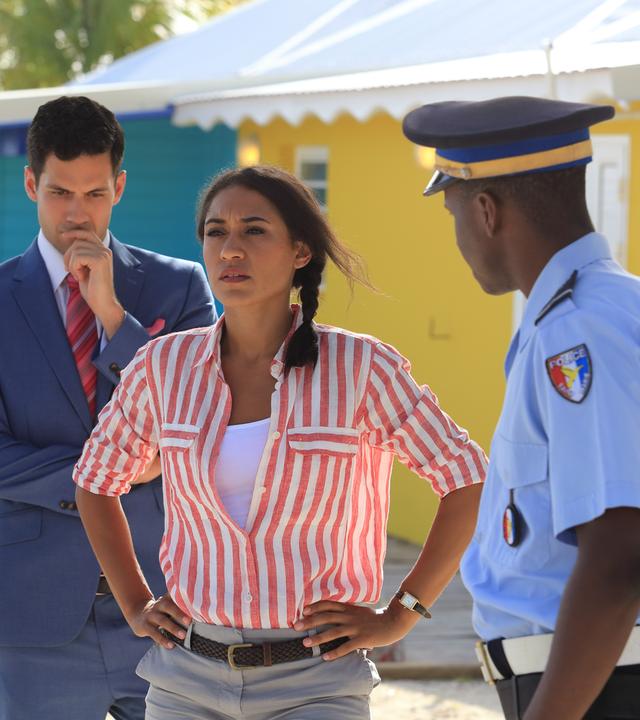 "Death in  Paradise - Die tote Braut": Florence Cassell (Josephine Jobert) steht zwischen Dwayne (Danny John-Jules), Oliver (Stefano Braschi) und J.P. (Tobi Bakare) und schaut in die Ferne.