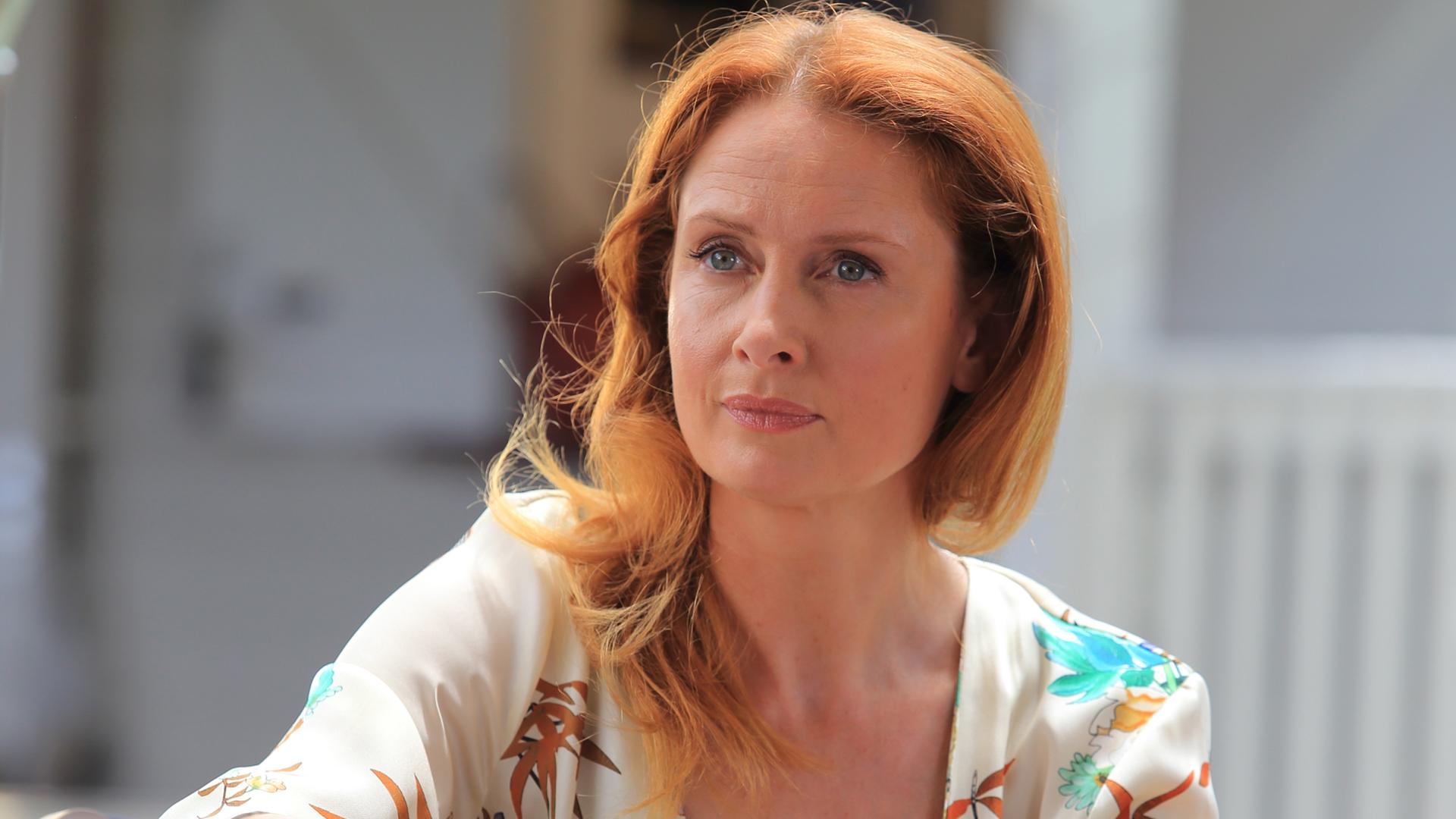 "Death in Paradise - Das letzte Spiel": Melanie Devaux (Zoe Telford) sitzt am Pokertisch hinter einem Stapel Pokerchips.