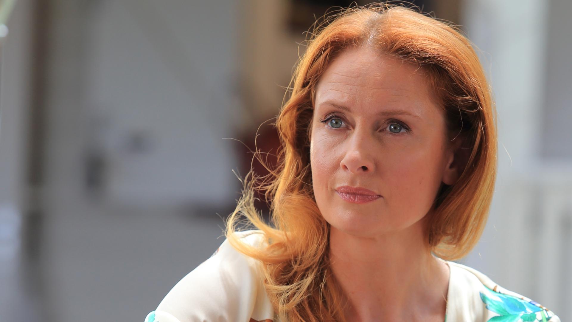 "Death in Paradise - Das letzte Spiel": Melanie Devaux (Zoe Telford) sitzt am Pokertisch hinter einem Stapel Pokerchips.
