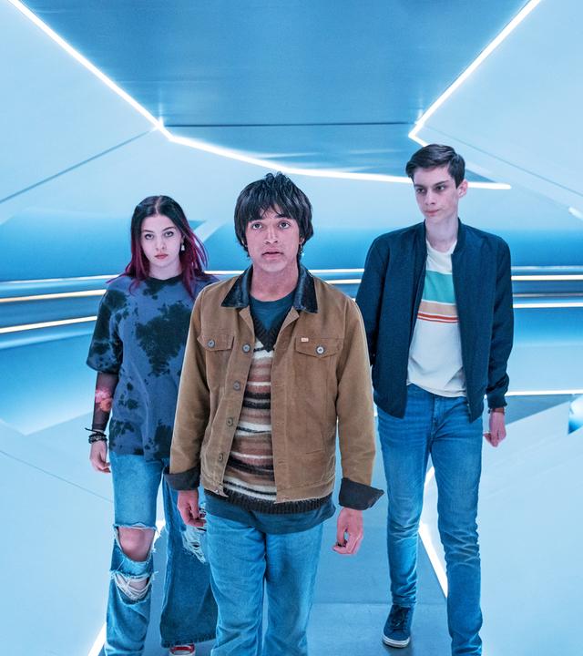 In einem hell erleuchteten bläulichen Raumschiffgang laufen Kaz und Louis hinter Jay her. Jay hat einen entschlossenen Blick.