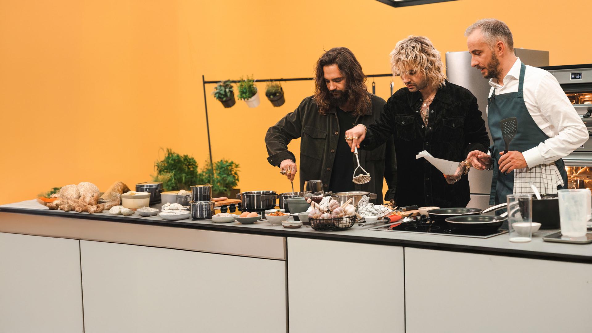 Tom (links) und Bill (Mitte) Kaulitz in der Küche mit Jan Böhmermann für die ZDFneo Koch-Talk Show Böhmi brutzelt