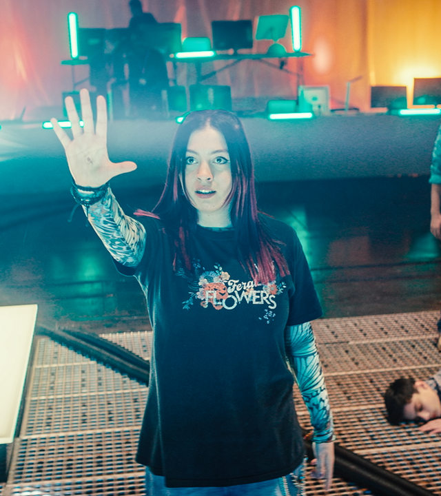 In der großen Halle auf dem Boden bei den Artefakten liegt Louis mit geschlossenen Augen. Bei ihm stehen Glen und Meg und beobachten Kaz. Kaz hat den Arm gehoben und aus ihrer gespreizter Hand kommt ein weißer dicker Lichtstrahl. Kaz schaut konzentriert in Richtung des Lichtstrahls.