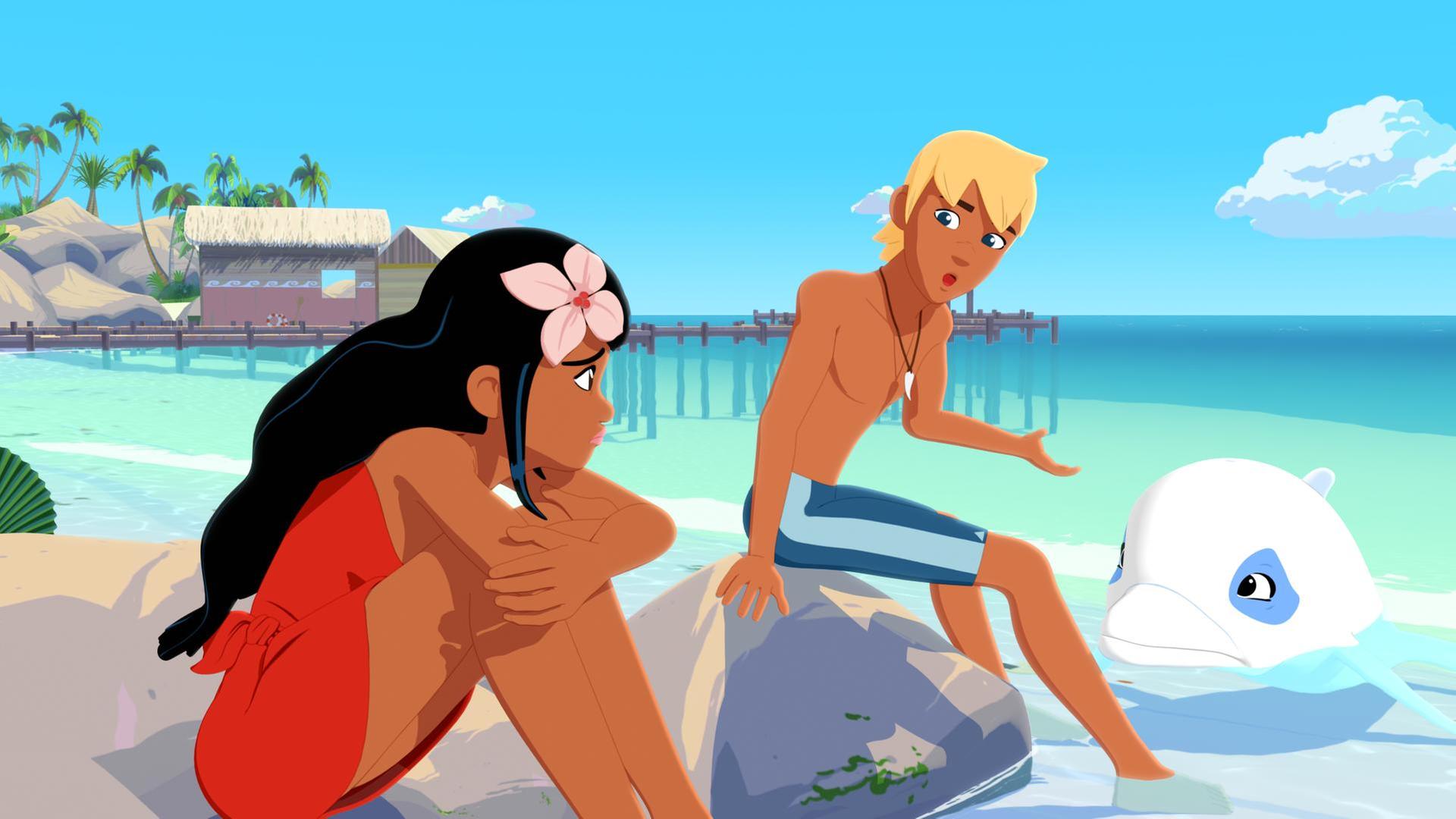 Timeti und Yann sitzen am Strand auf Steinen, die aus dem Wasser ragen. Vor ihnen im Wasser schwimmt Zoom. Hinter ihnen erstreckt sich die Bucht mit Bootsstegen und Hütten darauf. Yann spricht zu Timeti. Alle schauen einander ernst an.