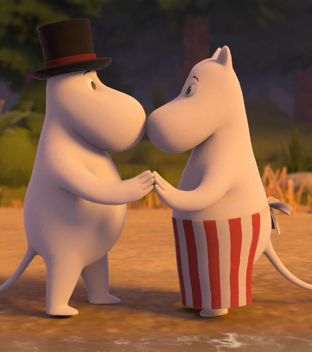 Sonnenuntergang: Am Meeresstrand stehen Muminmama (links) und die Kleine Mü. (rechts) Man sieht sie nur von hinten. Die Sonne färbt die Wolken gelb-rot und versinkt bald im Meer.