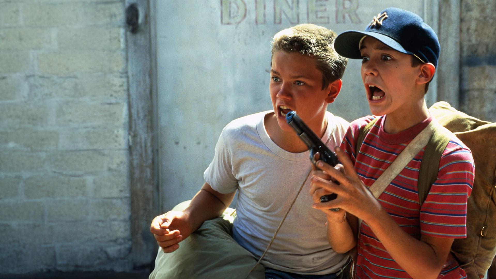 Mit aufgerissenen Mündern und Augen stehen Chris (River Phoenix, l.) und Gordie (Whil Wheaton) vor einer Wand.