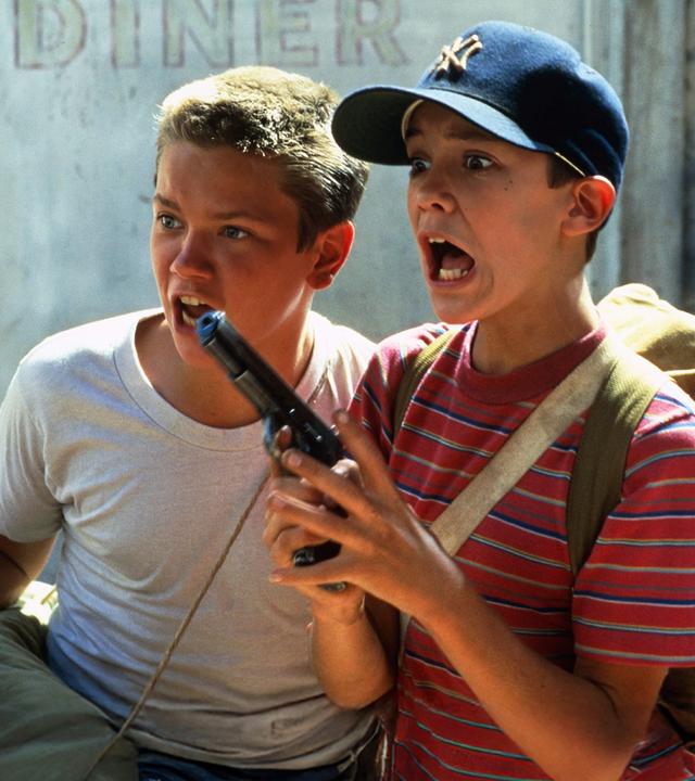 Mit aufgerissenen Mündern und Augen stehen Chris (River Phoenix, l.) und Gordie (Whil Wheaton) vor einer Wand.
