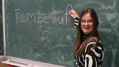 Charlotte Henning vor einer Schultafel.