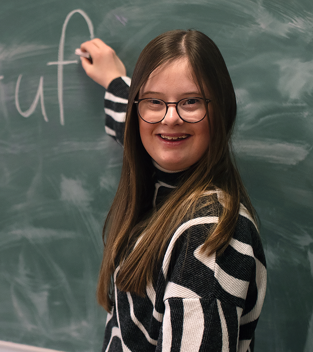 Charlotte Henning vor einer Schultafel.