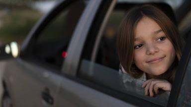 Mädchen schaut aus dem Auto Fenster