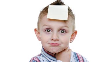 Kind mit Zettel auf der Stirn