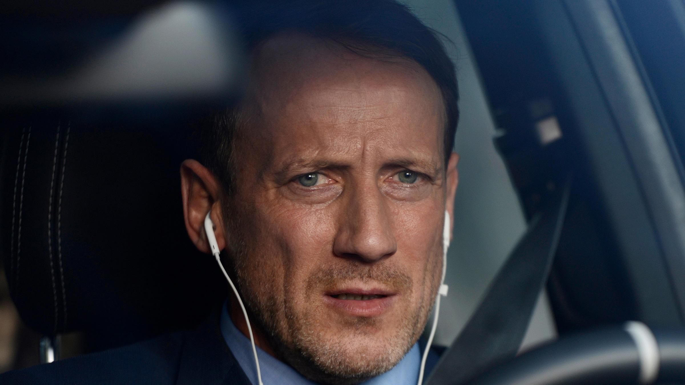 Karl Brendt (Wotan Wilke Möhring) sitzt am Steuer seines Wagens.