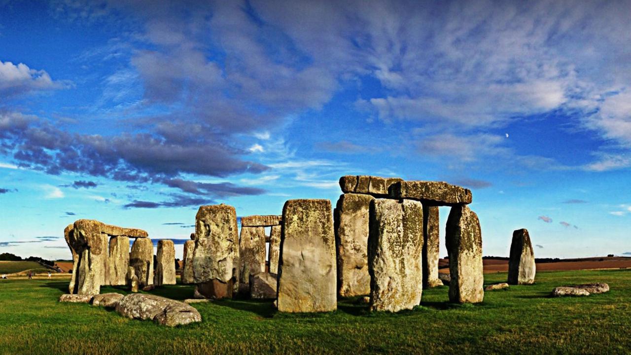 Der Steinkreis von Stonehenge vor blauem Himmel mit Wolken.