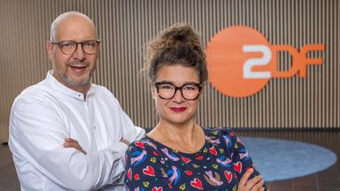 Der ZDF-Diversitätsbeauftragte Frank Rusko und die ZDF-Gleichstellungsbeauftragte Stephanie Keppler stehen nebeneinander vor eine ZDF-Logo