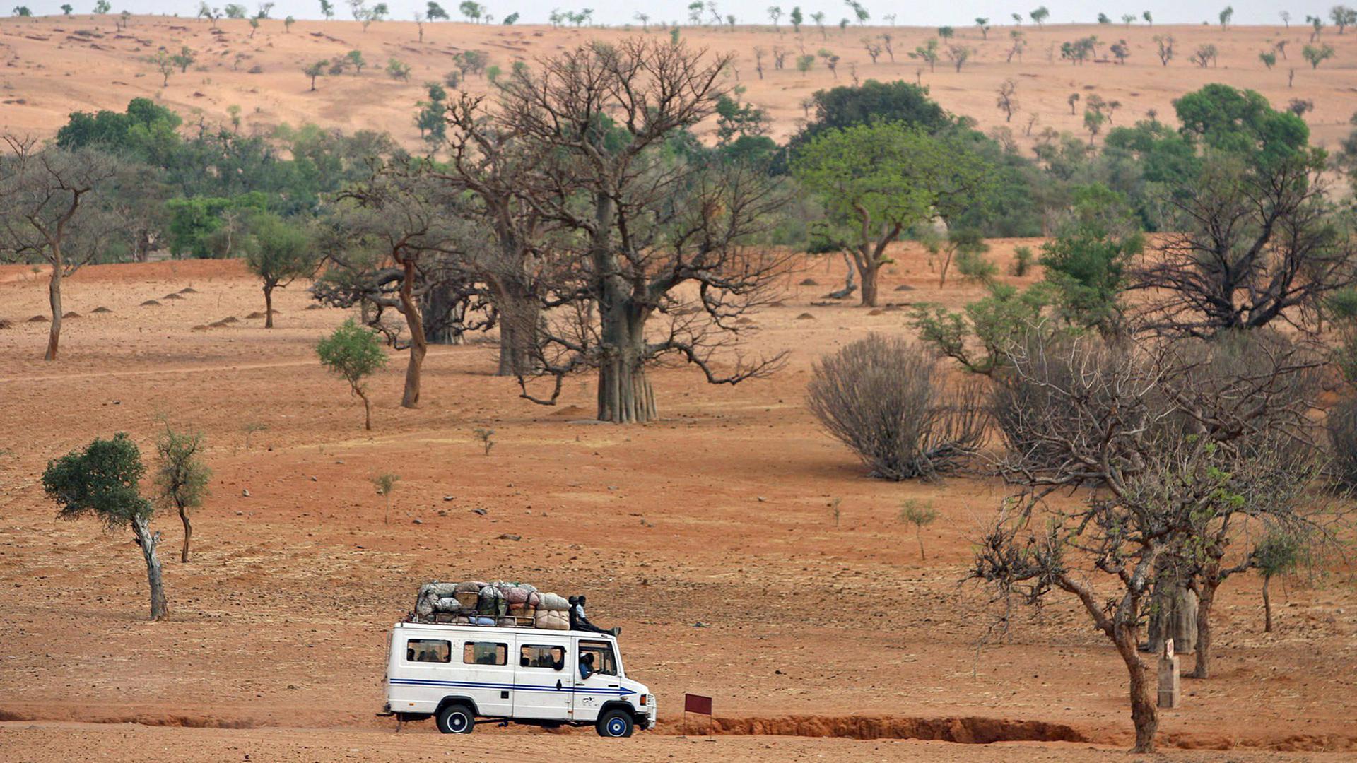 Ein Reisebus fährt durch die Wüste im zentralafrikanischen Mali