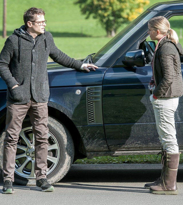 "Der Bergdoktor - Sternenhimmel (2)": Thomas Mannfeld (Roman Knižka) und Lisa Unger (Merle Collet) stehen sich mit einigem Abstand vor einem Auto gegenüber.