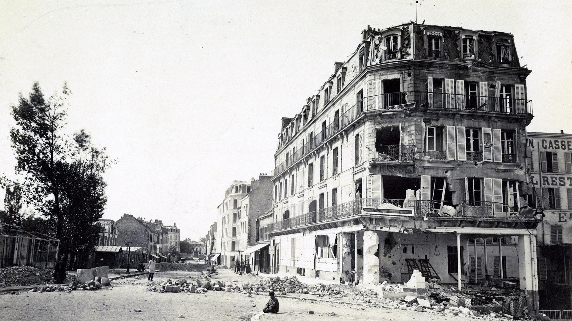 "Stimmen aus dem Krieg - Deutsche und Franzosen 1870/1871 - Der Kriegsberichterstatter": Schwarz-Weiß-Aufnahme. Ansicht einer zerstörten Straße: die Ruinen in der Grande Rue in Asnières-sur-Seine, Paris.