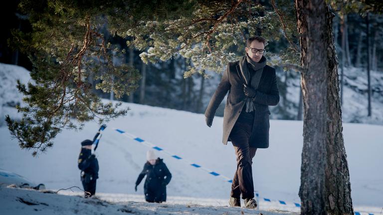 Alex Recht läuft durch den Schnee, seine Kollegin Fredrika Bergman läuft ein Stück entfernt hinter ihm