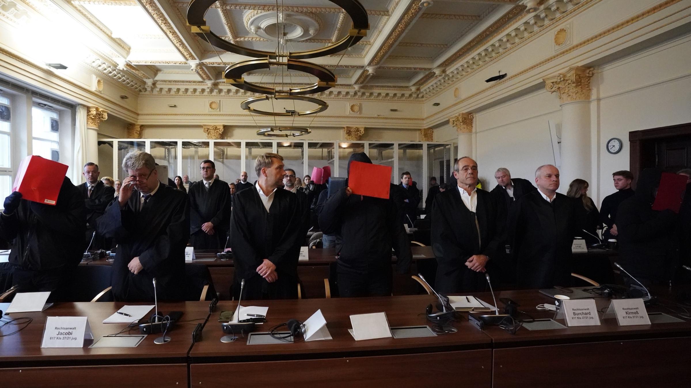 Die Angeklagten stehen neben ihren Anwälten im Prozess um Vergewaltigung einer Jugendlichen im Stadtpark in Hamburg, 28.11.2023.