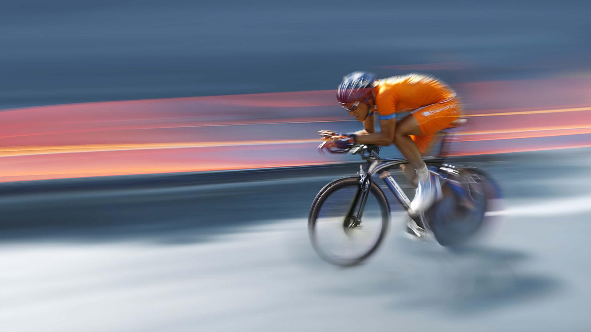 Symbolbild: Ein Mann auf einem Fahrrad, stilistisch verzerrt, um Schnelligkeit anzudeuten