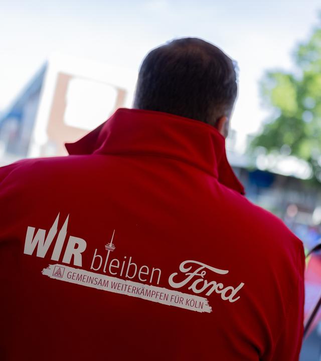  Ein Mitarbeiter trägt eine Jacke mit der Aufschrift Wir bleiben Ford - Gemeinsam weiterkämpfen für Köln beim ersten Streik der Geschichte vor den Kölner Ford-Werken. 