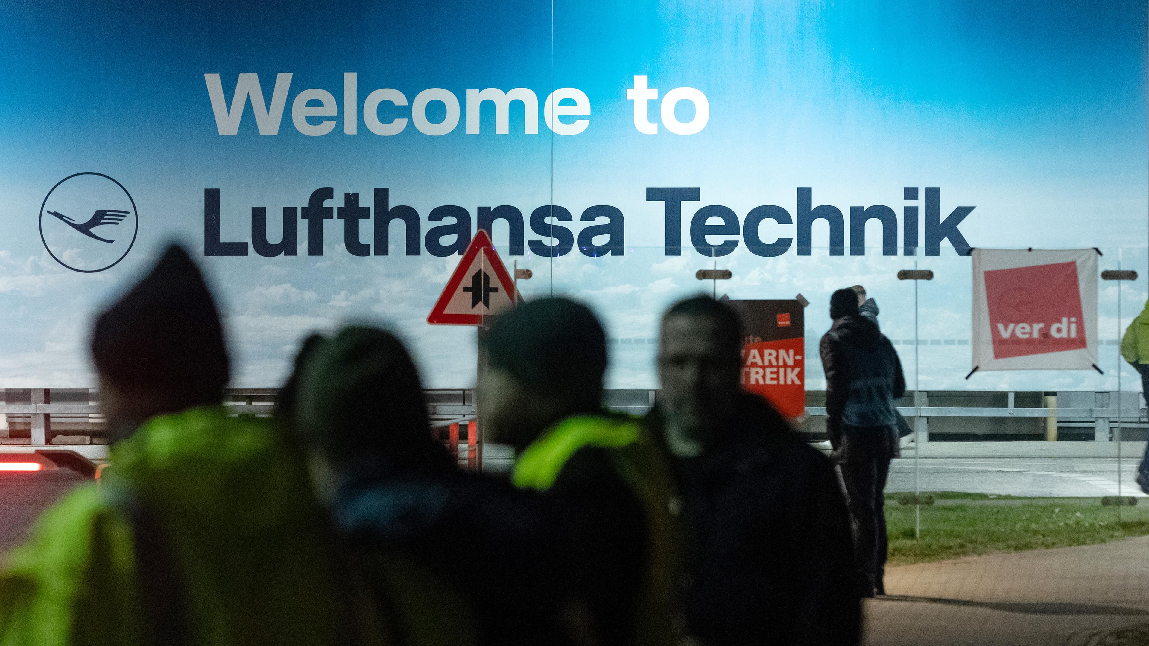 Blick auf den Eingangsbereich zur Lufthansa Technik in Hamburg, vor dem sich auch Streikende versammelt haben, aufgenommen am 28.02.2024 in Hamburg