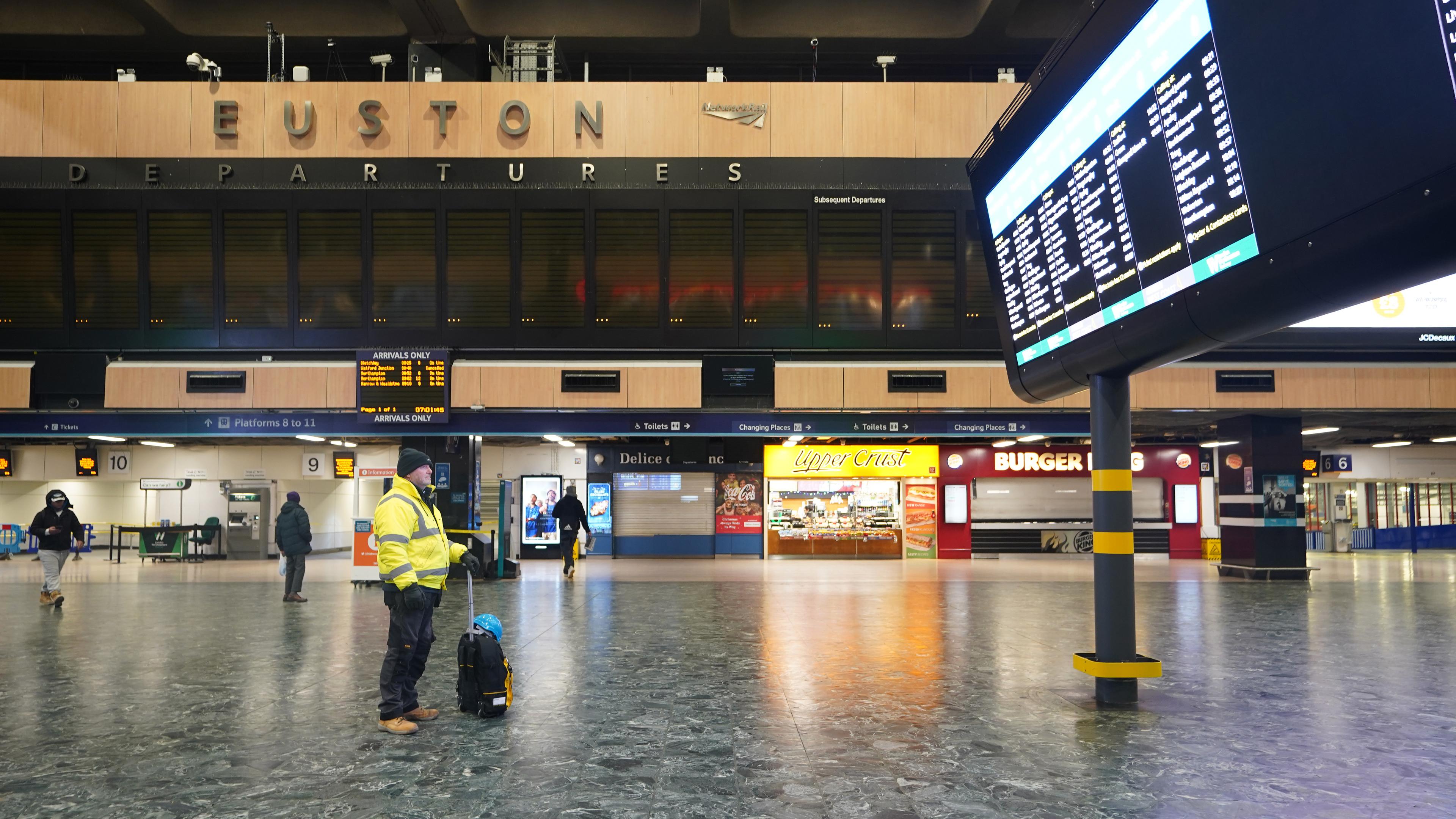 Ein Mann betrachtet die Abfahrtstafel im Bahnhof Euston in London während eines Streiks, aufgenommen am 14.12.2022