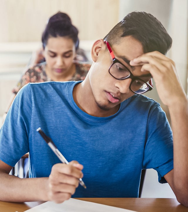 Schüler in der Schule schreiben eine Arbeit.