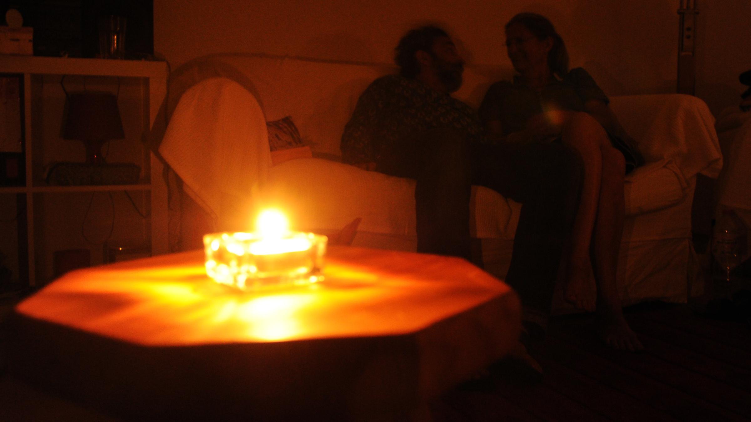 Nordrhein-Westfalen, Hannover: Ein Paar sitzt während eines Stromausfalls bei Kerzenschein in einer Wohnung in Hannover. Archivbild