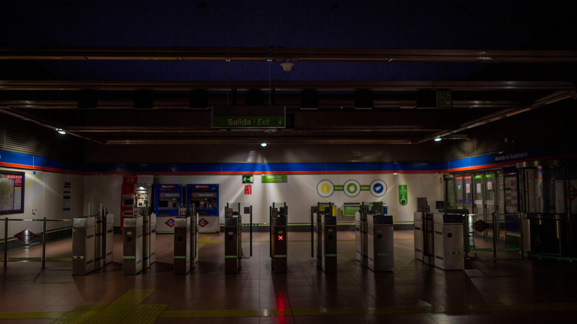 Leere, weitgehend dunkle U-Bahn-Station mit Tickettoren
