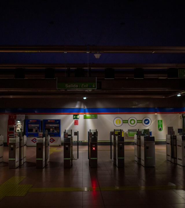 Leere, weitgehend dunkle U-Bahn-Station mit Tickettoren