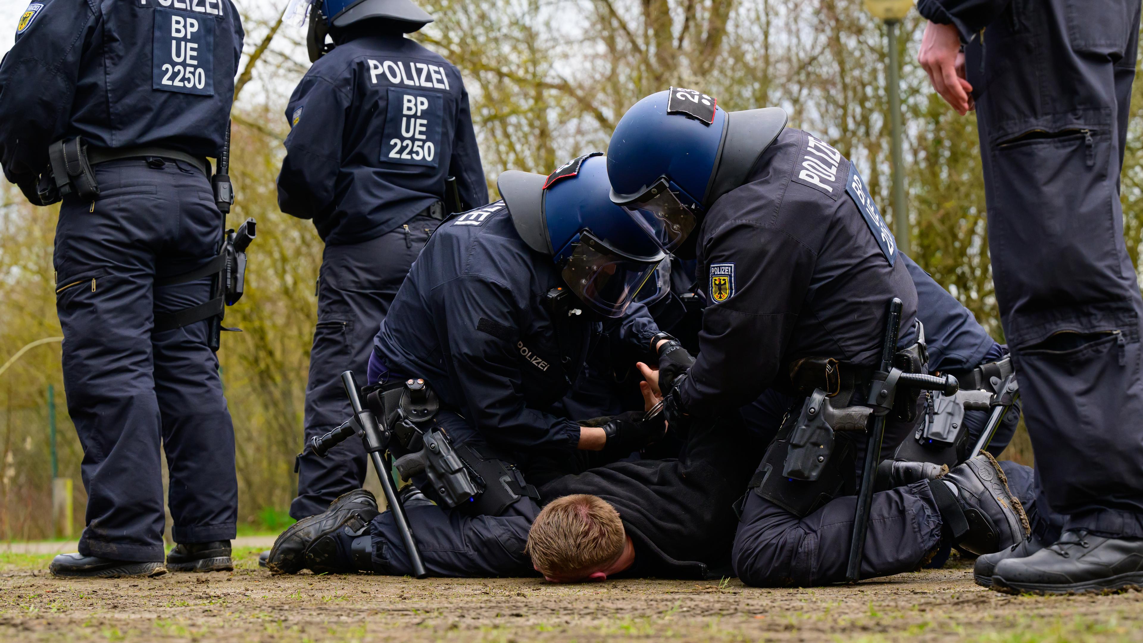 Polizisten der Bundespolizei nehmen während einer Übung einen Fußballfan fest.