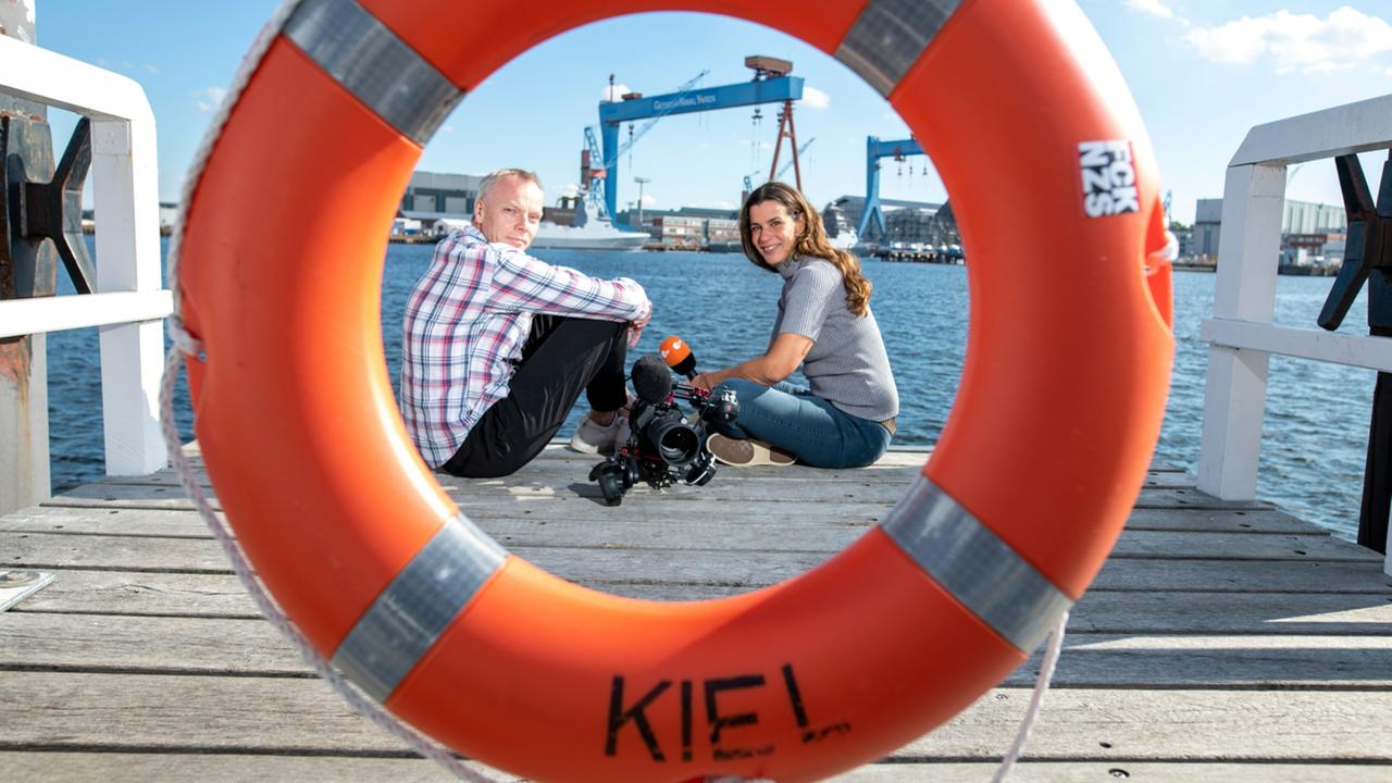 Redakteurin Sohad Khaldi mit Teamleiter Gerd Breckling vom ZDF-Landesstudio Schleswig-Holstein auf Steg an der Kieler Förde.