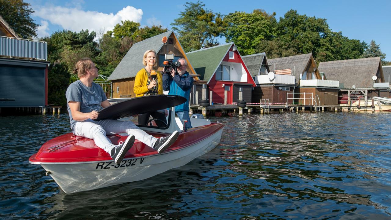 Kameraassistent Christian Reuter, ZDF-Redakteurin Susanne Seidl und Kameramann Dirk Bethage bei Drehtermin auf kleinem Boot.