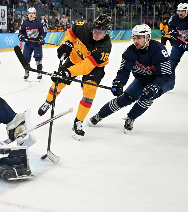 Der deutsche Eishockeyspieler Tim Stützle setzt sich bei den Olympischen Winterspielen 2026 in Cortina  gegen seinen französischen Gegenspieler Hugo Gallet durch und kann auf das Tor schießen