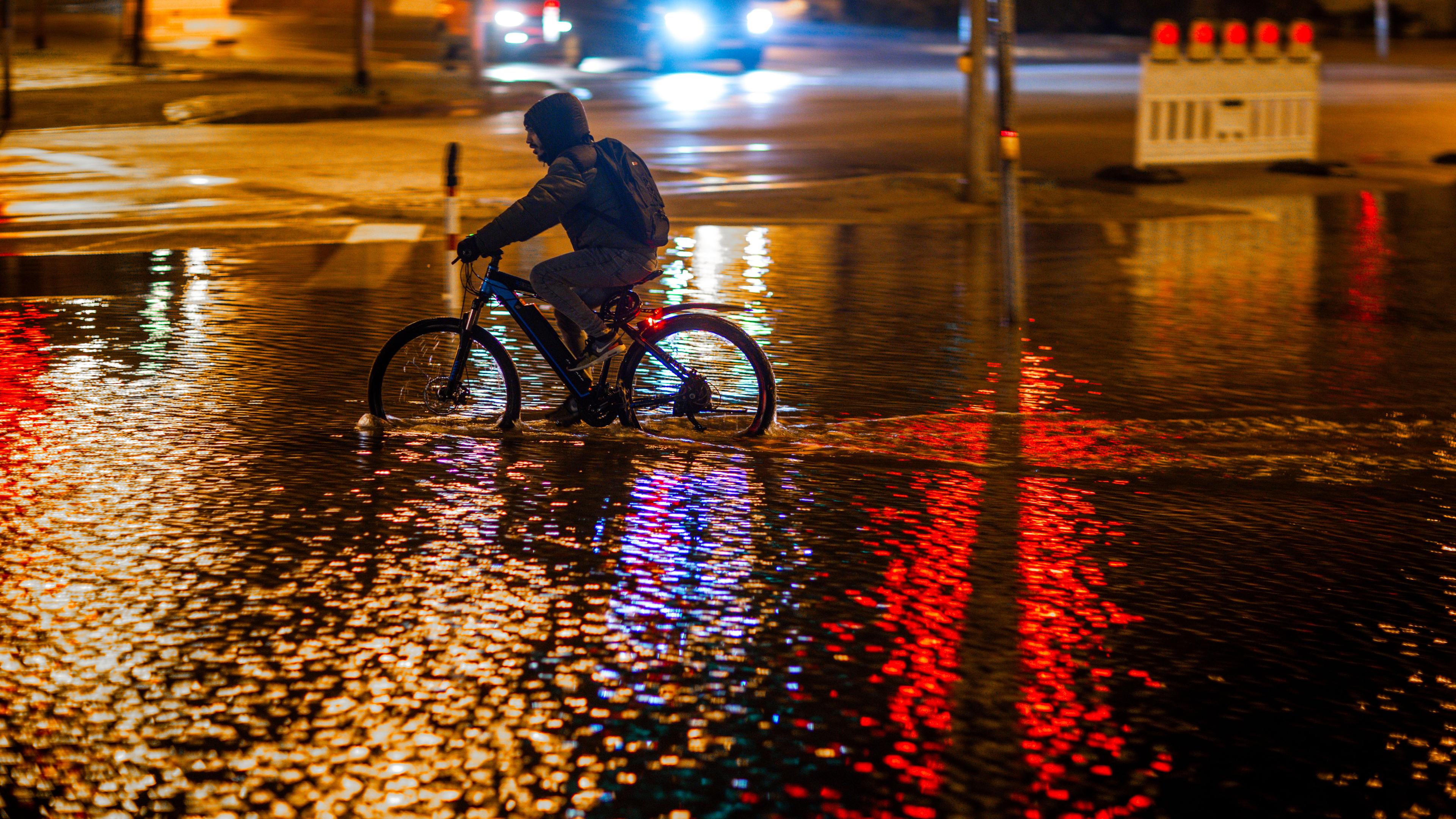 Ein Radfahrer fährt durch das Hochwasser am Stadthafen von Wismar in Mecklenburg-Vorpommern.