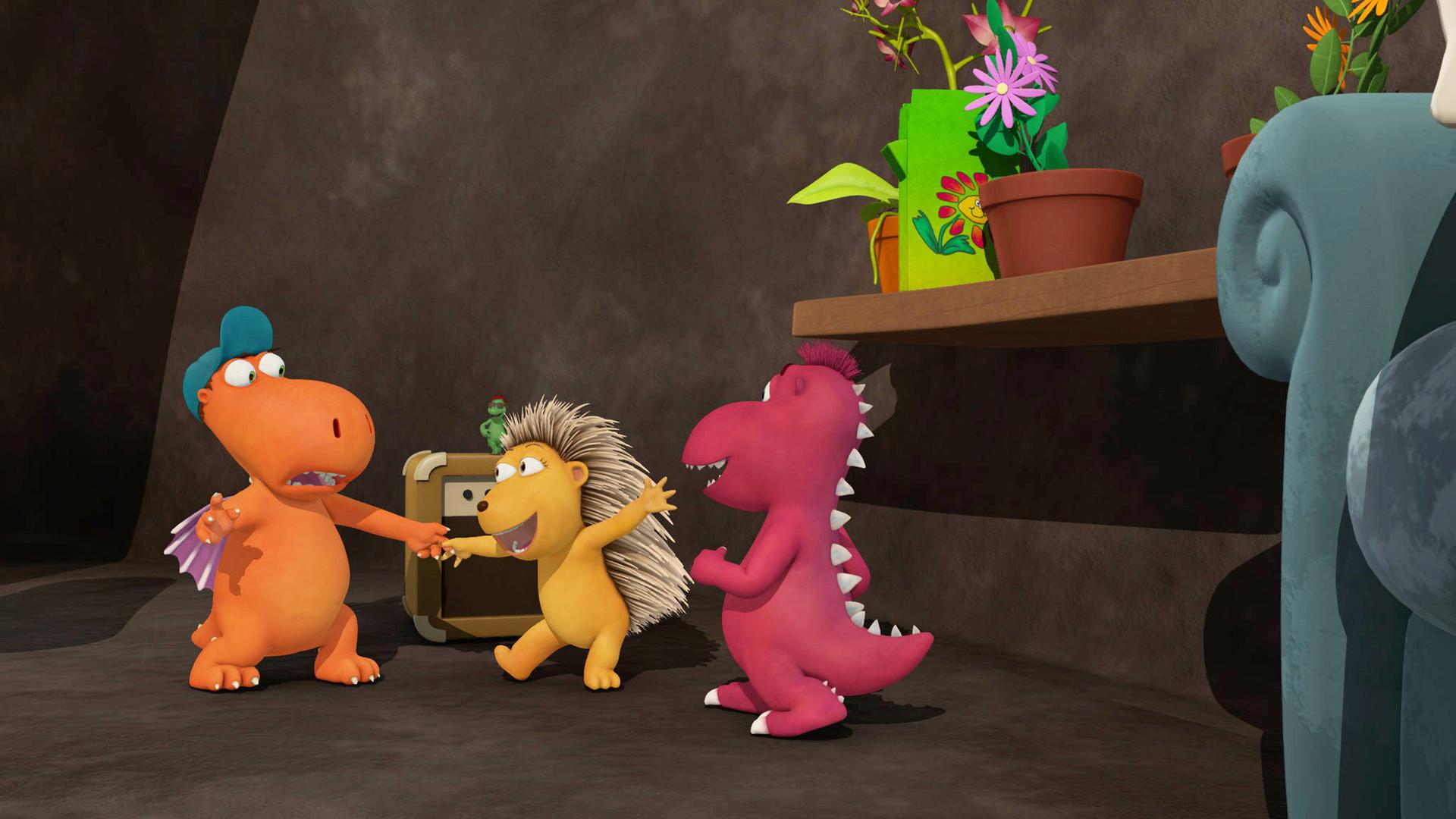 Kokosnuss hält Matilda an der Hand und tanzt mit ihr, Oskar steht daneben in der Höhle.