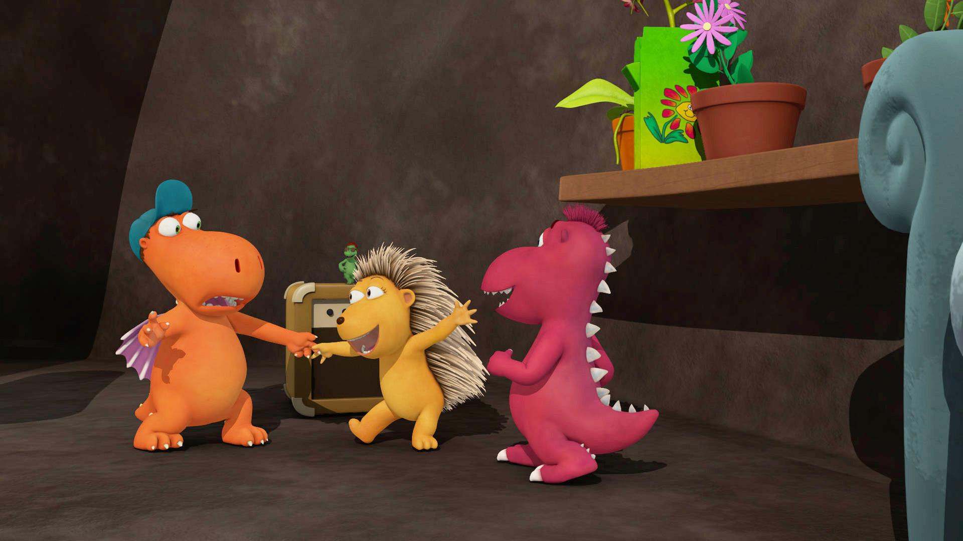 Kokosnuss hält Matilda an der Hand und tanzt mit ihr, Oskar steht daneben in der Höhle.