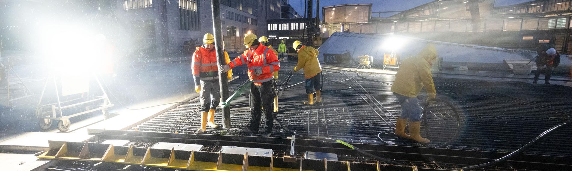 Arbeiter betonieren das letzte Stück des Dachs des neuen Tiefbahnhofs im Rahmen des milliardenschweren Bahnprojekts Stuttgart 21 am 28.11.2023.