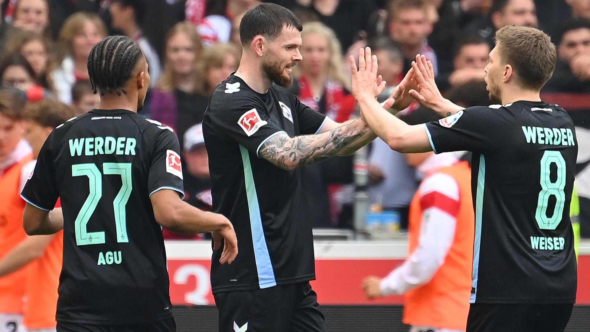 Bremens Oliver Burke und Mitchell Weiser jubeln nah dem Tor gegen Stuttgart beim Spiel am 13.04.2025.