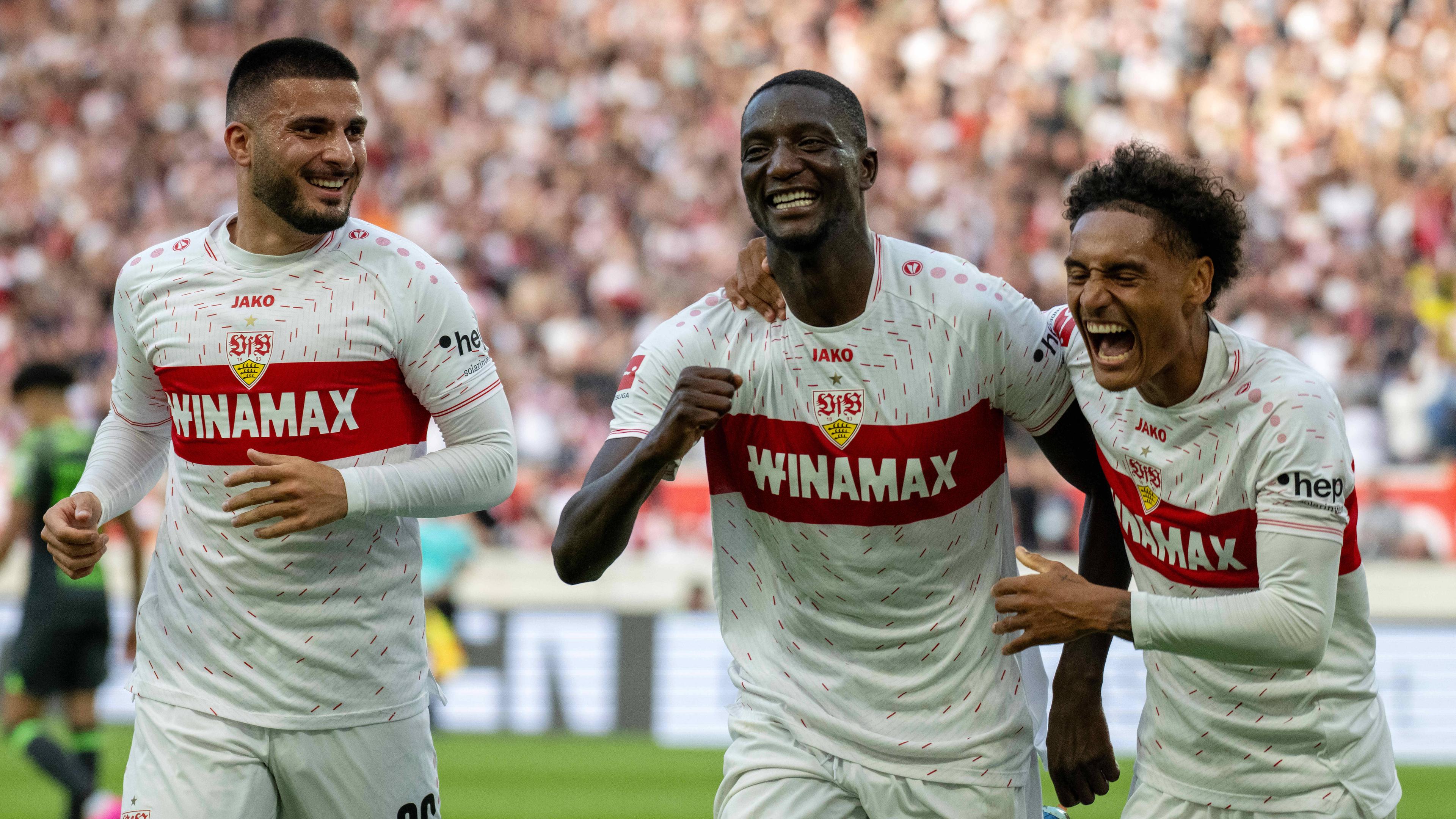 Stuttgarts Torschütze Serhou Guirassy jubelt mit Deniz Undav und Enzo Millot beim Spiel gegen Wolfsburg am 07.10.2023.