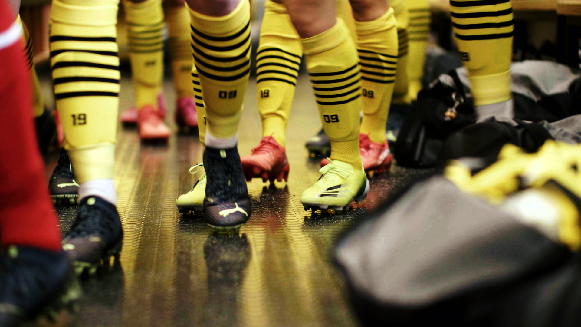 Unterschenkel von Fußballerinnen mit Fußballschuhen und gelb-schwarzen Stutzen des BVB